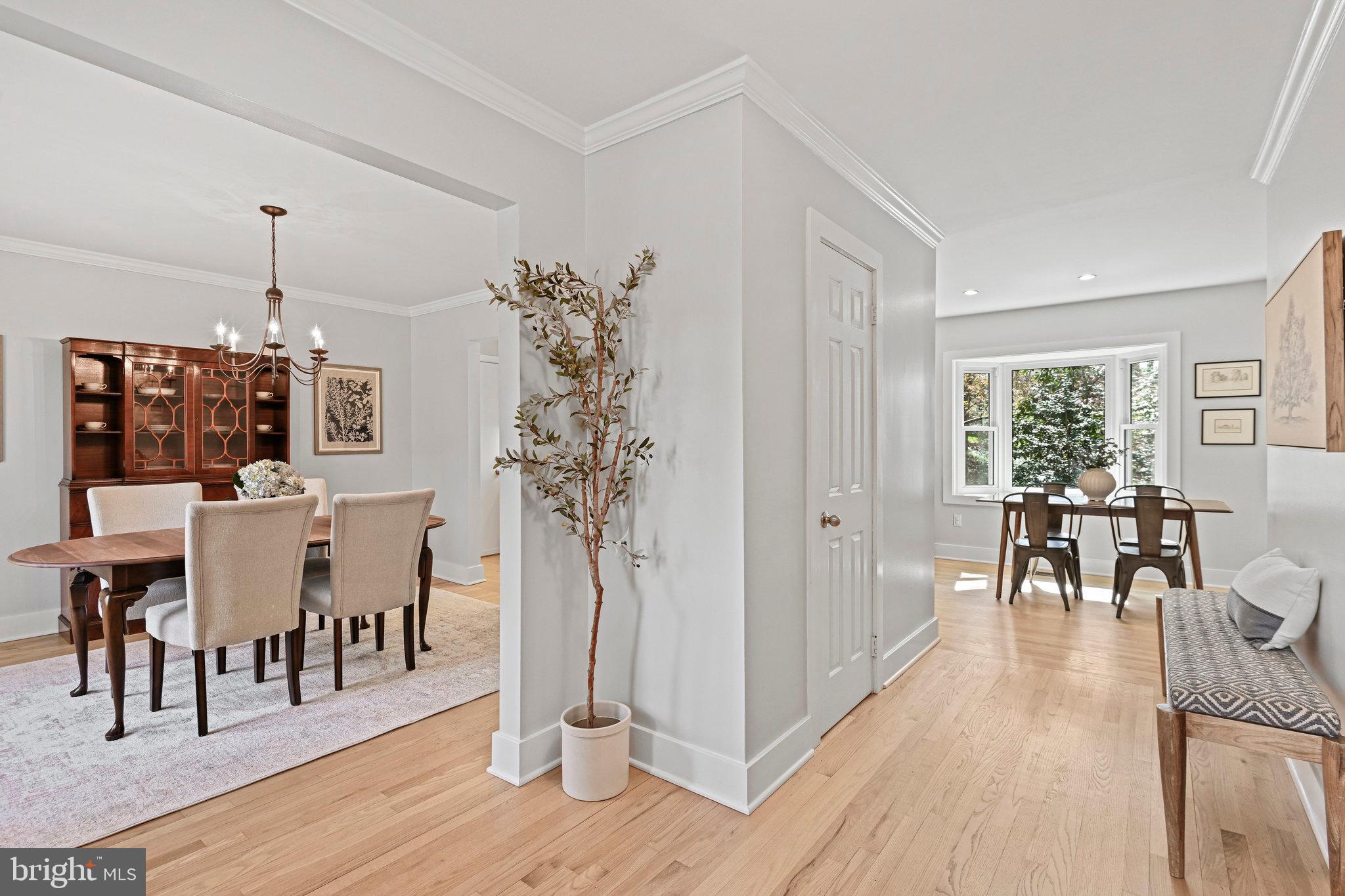 Dining room with a wood table, chandelier, built-in china cabinet, and bright adjacent breakfast nook.