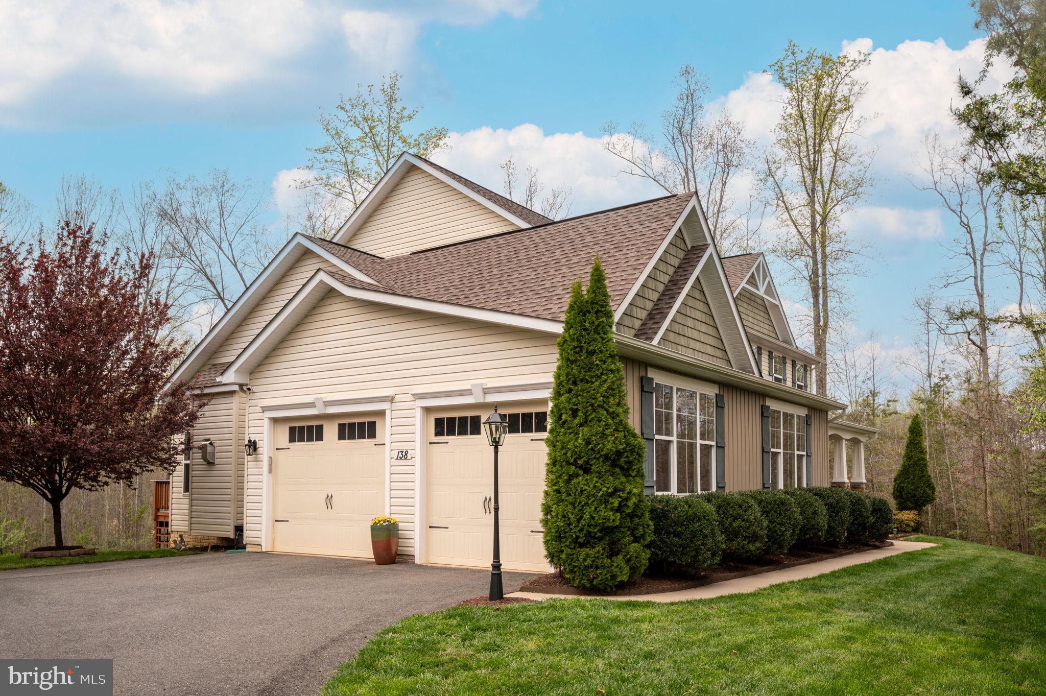 House at 138 Donovan Ln with multiple gables, a two-car garage, and landscaped shrubs.