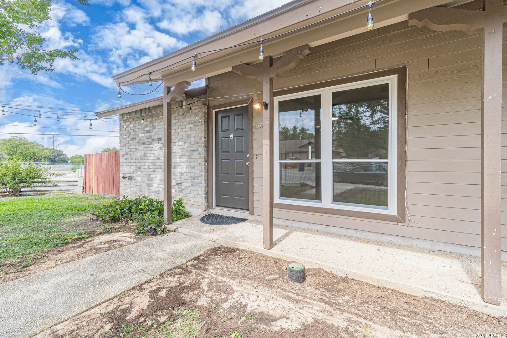 House exterior with a covered porch, gray front door, and large double window.