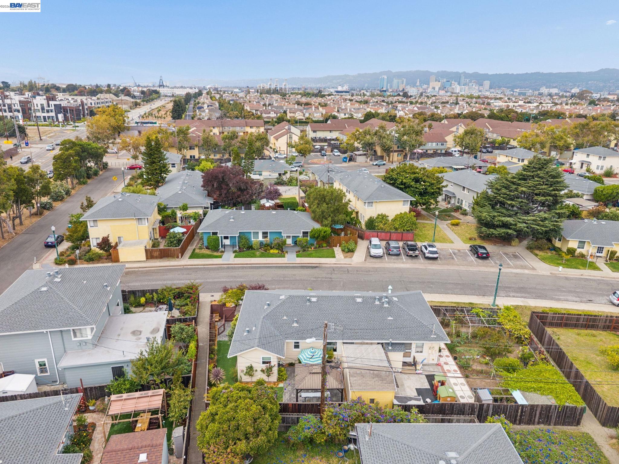 Aerial view of homes around 104 Cypress Street, with a distant city skyline.