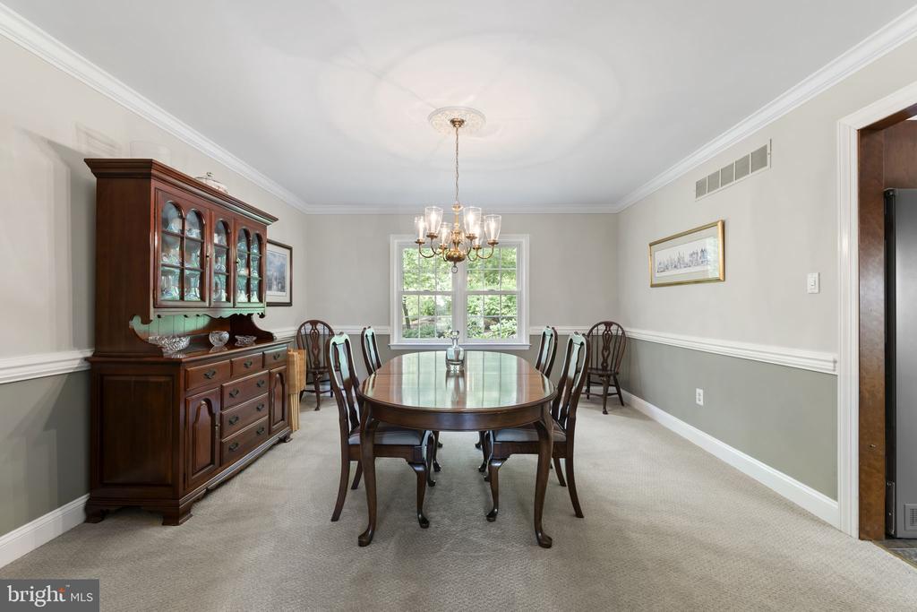 Dining room with an oval table, dark wood china cabinet, and chandelier.