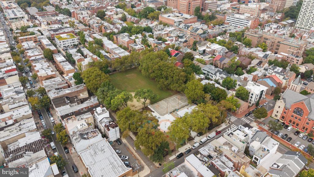 Aerial view of a Philadelphia neighborhood park with courts, lawn, and surrounding buildings.