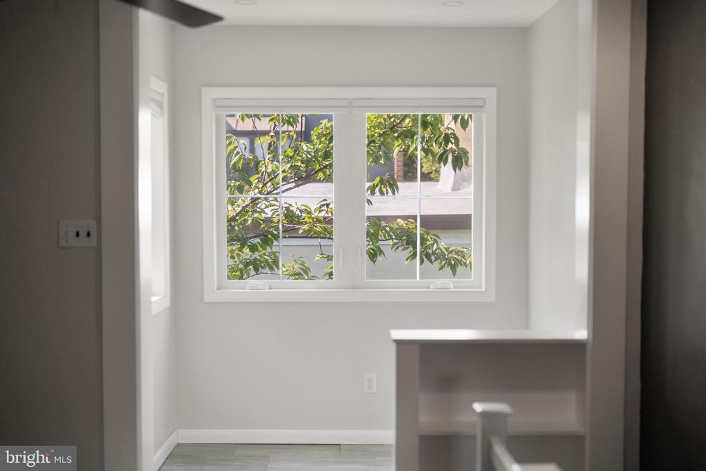 Bright interior with a large window overlooking leafy trees and a short counter.