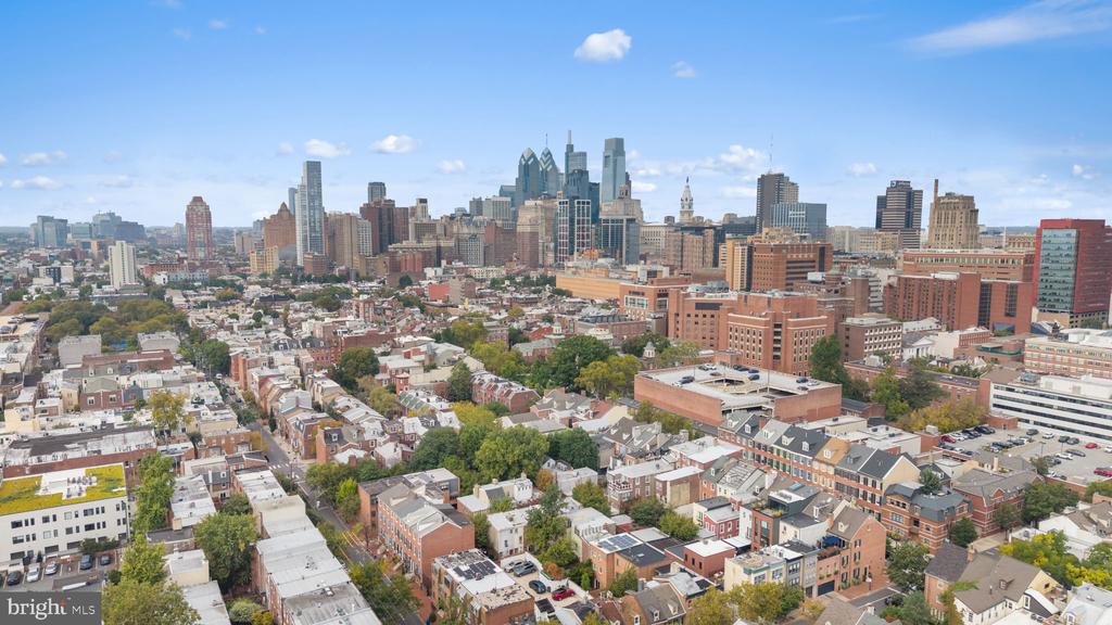 Aerial view of Philadelphia row houses and downtown skyline on a clear day.