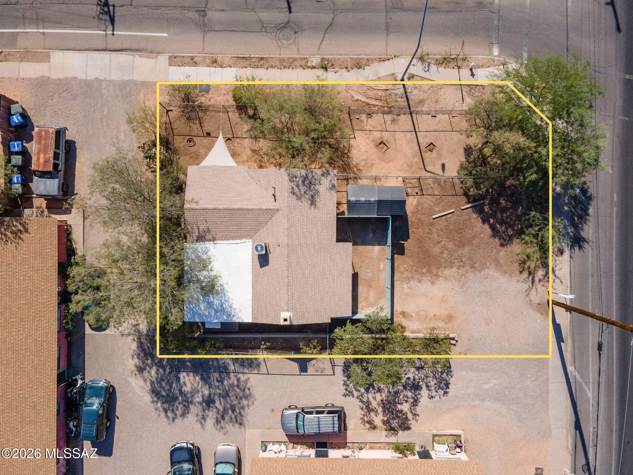 Aerial view of a single-story home and mostly bare yard outlined in yellow.