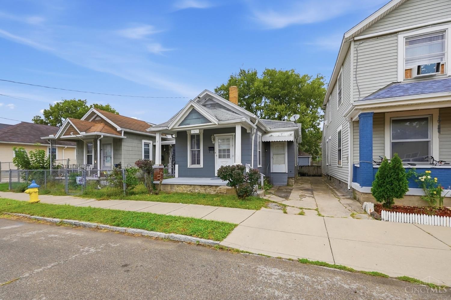 Blue-gray bungalow at 249 Air Street with a covered porch and neighboring homes.
