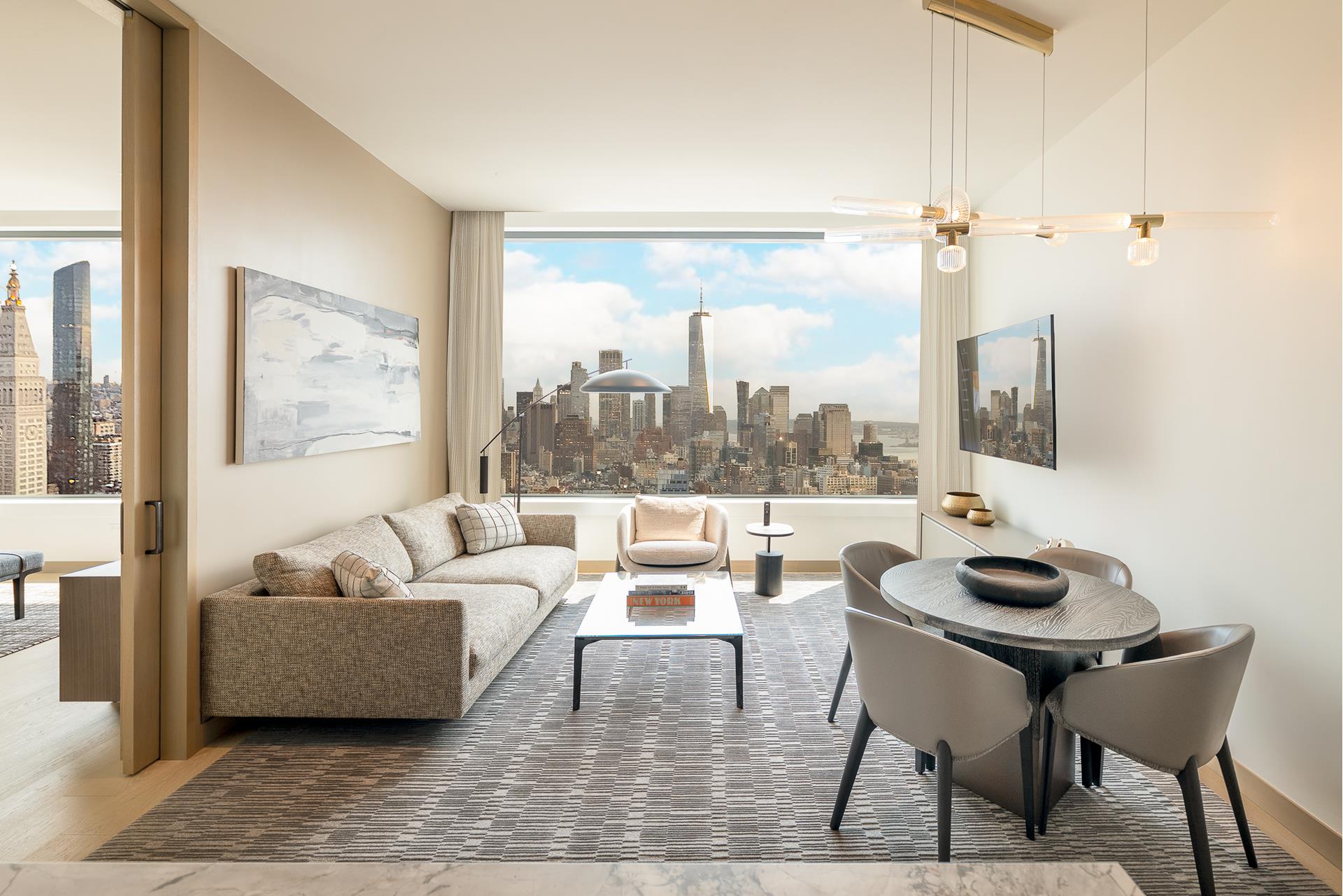 Furnished living and dining room with expansive windows overlooking the Manhattan skyline.