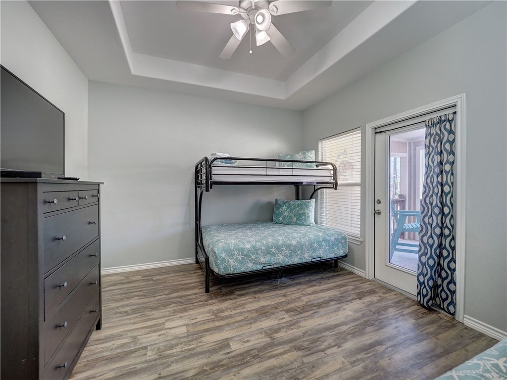 Bedroom with a metal bunk bed, turquoise starfish bedding, and a glass balcony door.