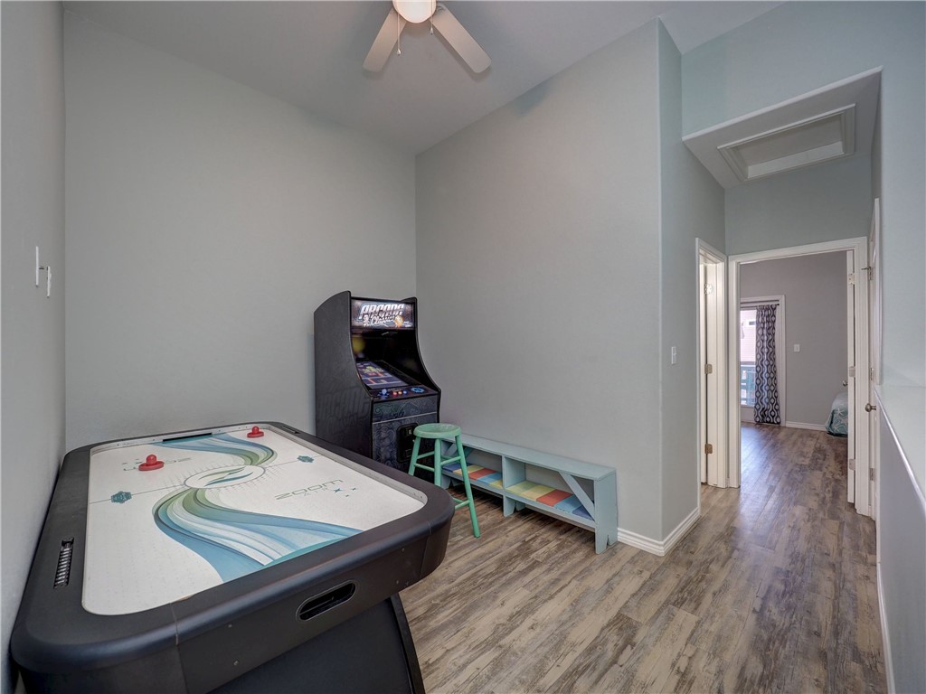 Game room with an air hockey table, arcade cabinet, and low cubby bench.
