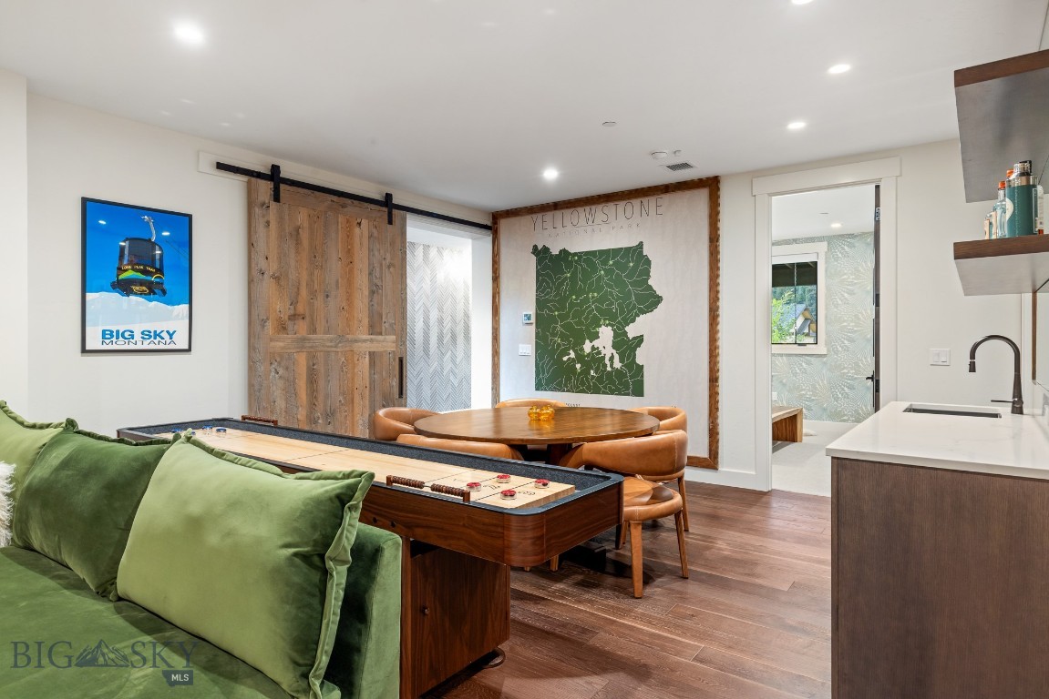 Furnished living area with a wooden shuffleboard table, round dining table, and Yellowstone map.
