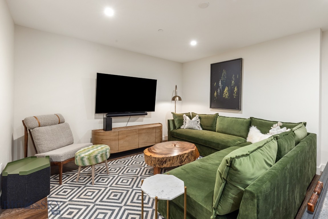 Living room with a green sectional, geometric rug, and live-edge coffee table.