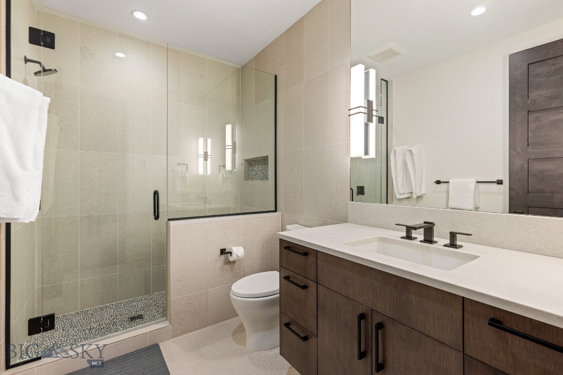 Modern bathroom with a glass shower and dark wood vanity.