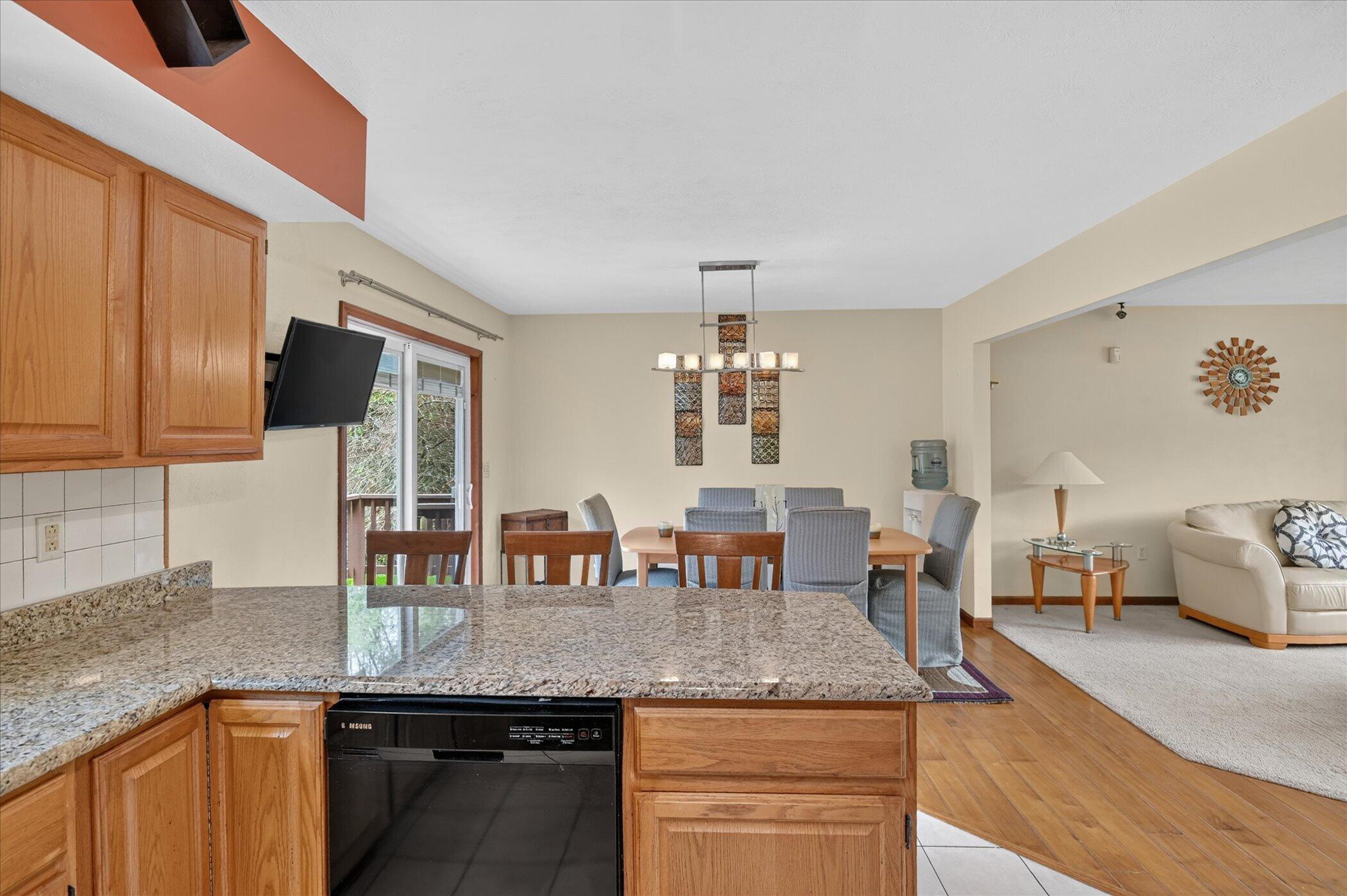 Open-plan kitchen with granite counters overlooks a dining area and living room.