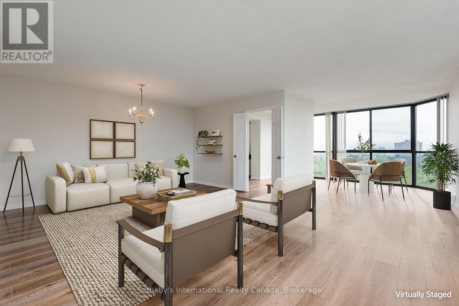 Staged condo living and dining room with floor-to-ceiling windows overlooking trees and distant buildings.
