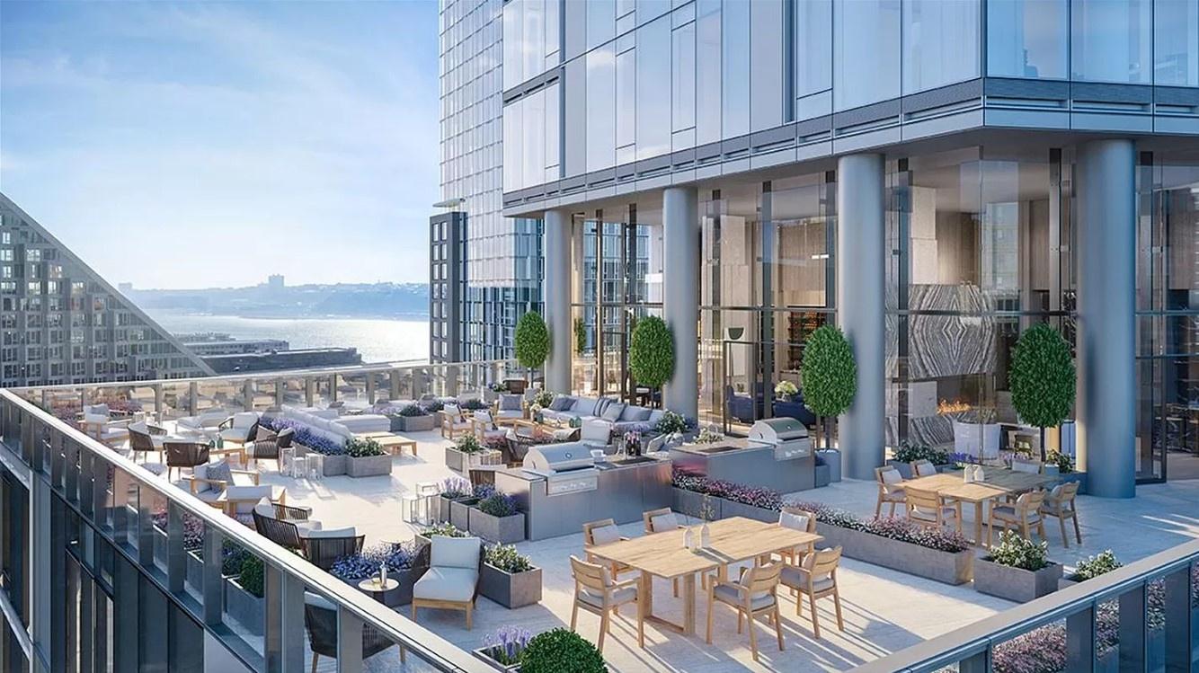 Rooftop terrace with outdoor dining and lounge seating overlooking the waterfront.