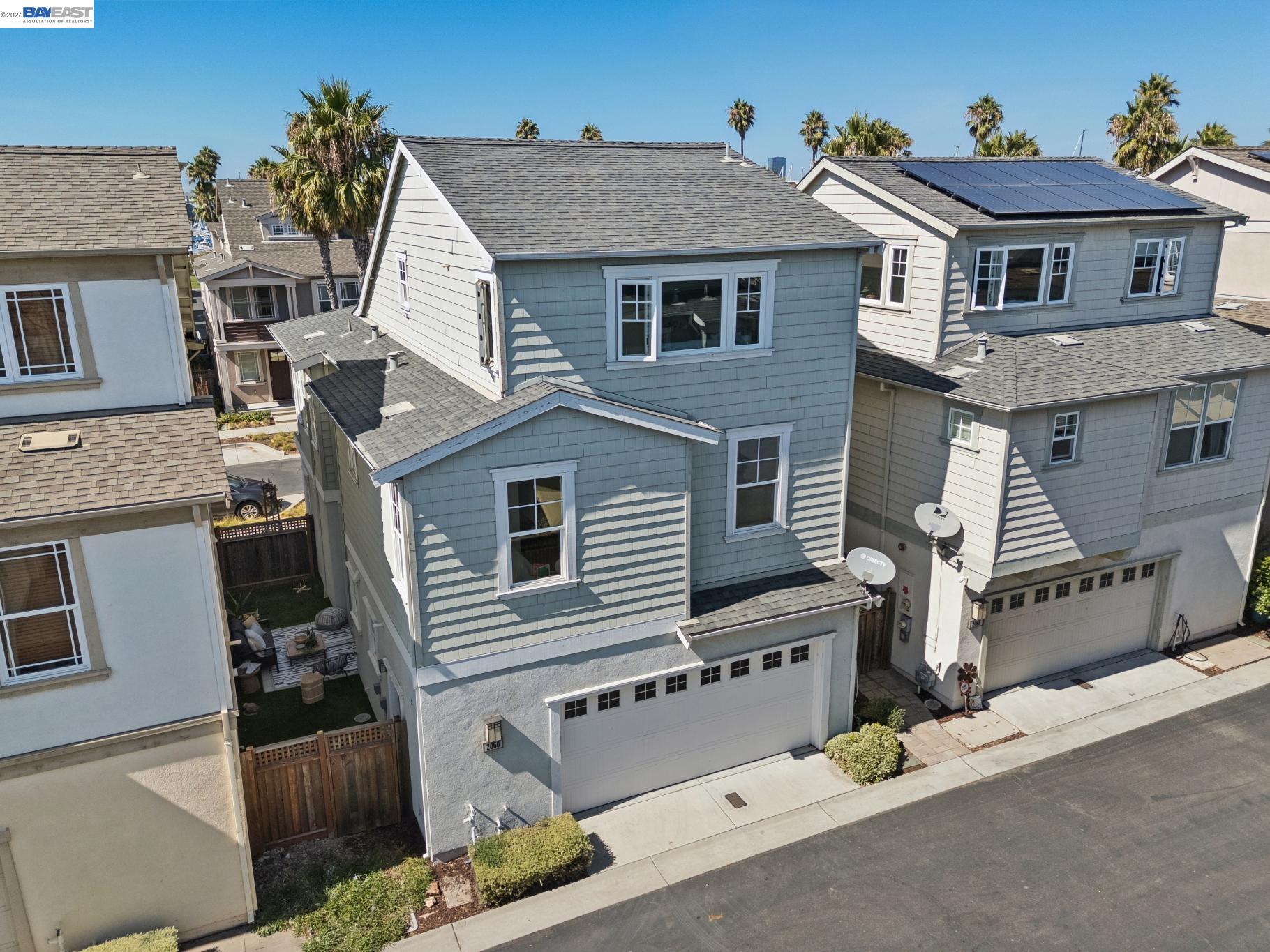 Aerial view of a blue-gray multi-story house with white trim and a two-car garage.
