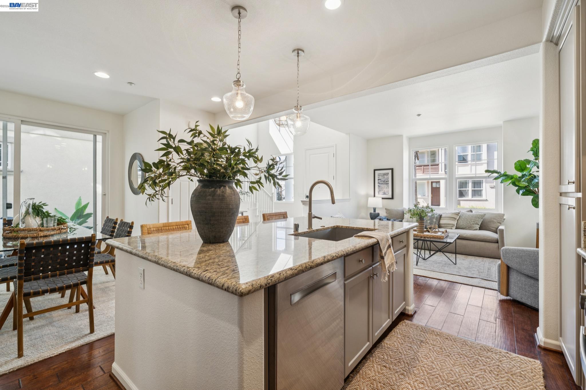 Open-plan kitchen with a large granite island overlooking the dining and living areas.
