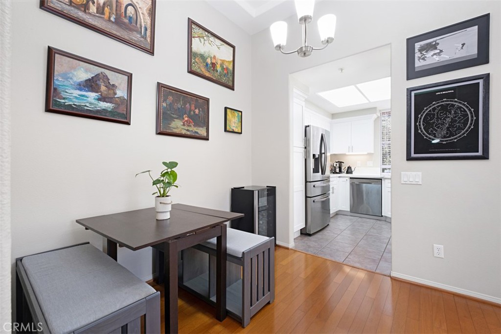 Dining nook with a dark wood table and gray bench seating beside a bright kitchen.