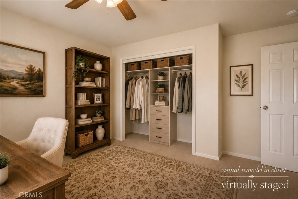 Walk-in closet with built-in drawers and shelves, hanging clothes, and a patterned rug.
