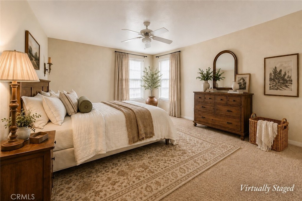 Virtually staged bedroom with a large bed, wooden dresser, and patterned area rug.