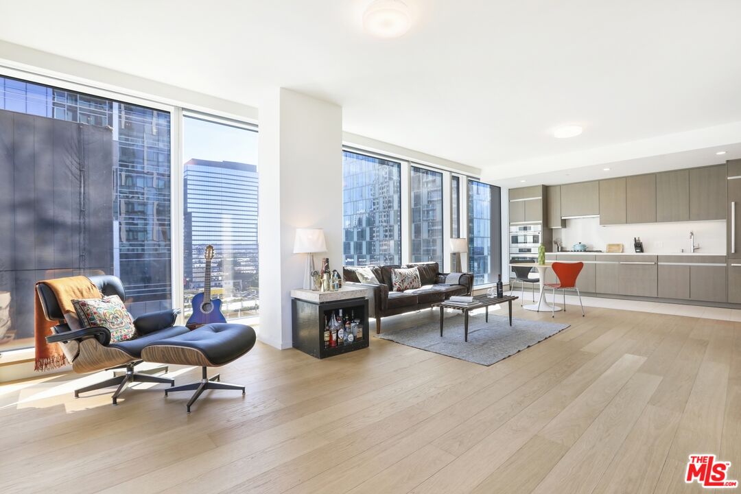 Open-plan living room and kitchen with floor-to-ceiling windows overlooking the city.