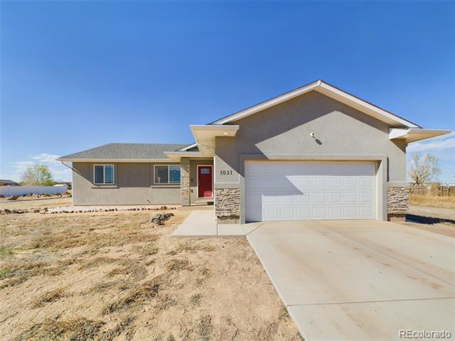 Single-story gray stucco home with a white garage, red front door, and dry front yard.