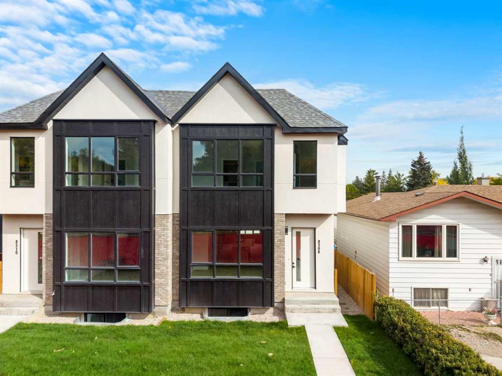 Modern attached homes with dark window framing, stone accents, and a green front lawn.