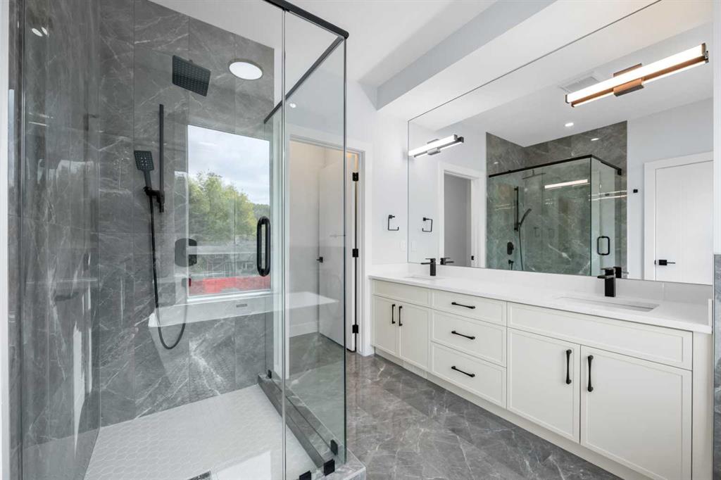 Modern bathroom with a glass walk-in shower and a long white vanity.