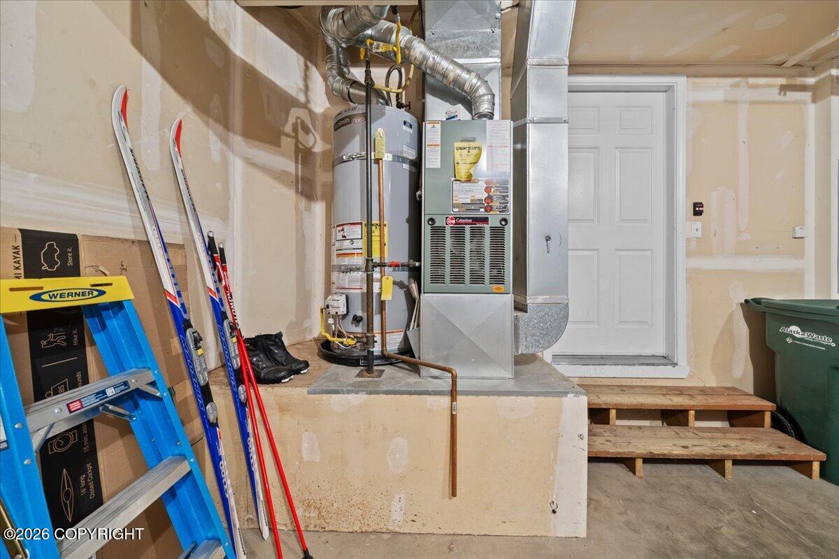 Basement utility area with a water heater, furnace, exposed ductwork, and rough steps to a white door.