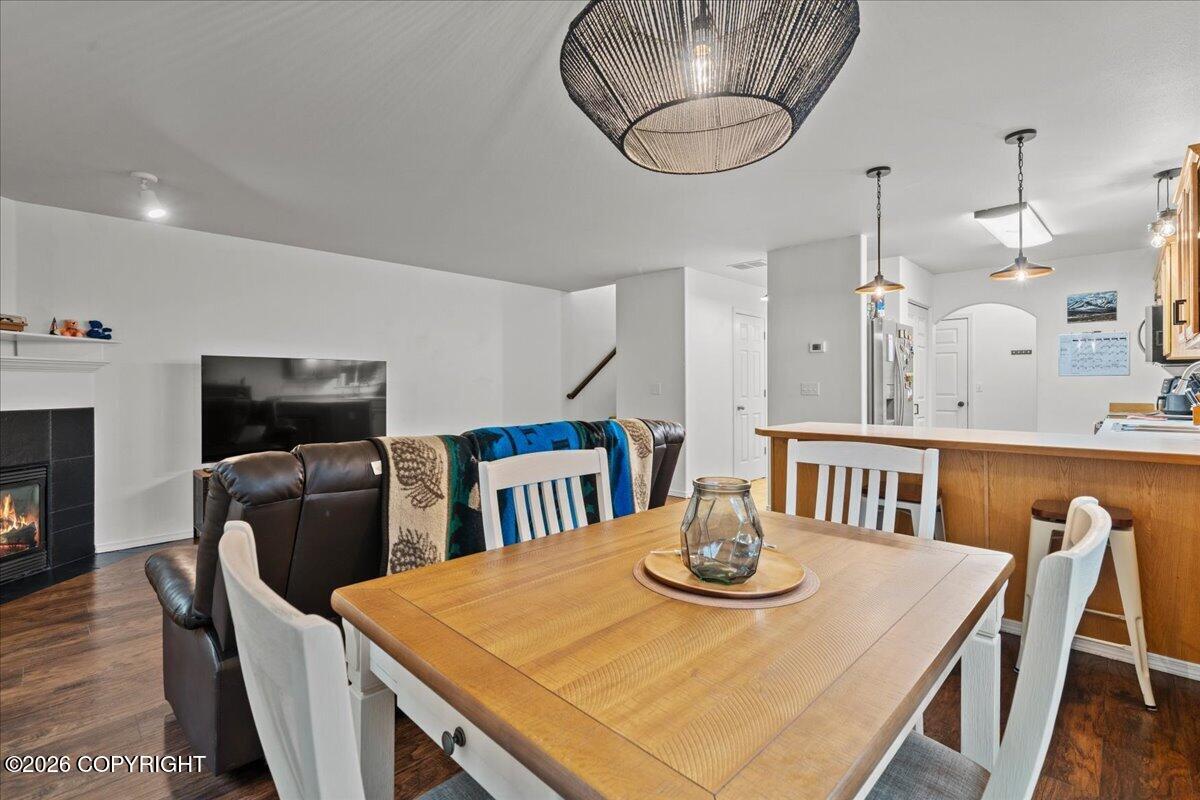 Dining area with a large wooden table, adjoining living room, and fireplace.