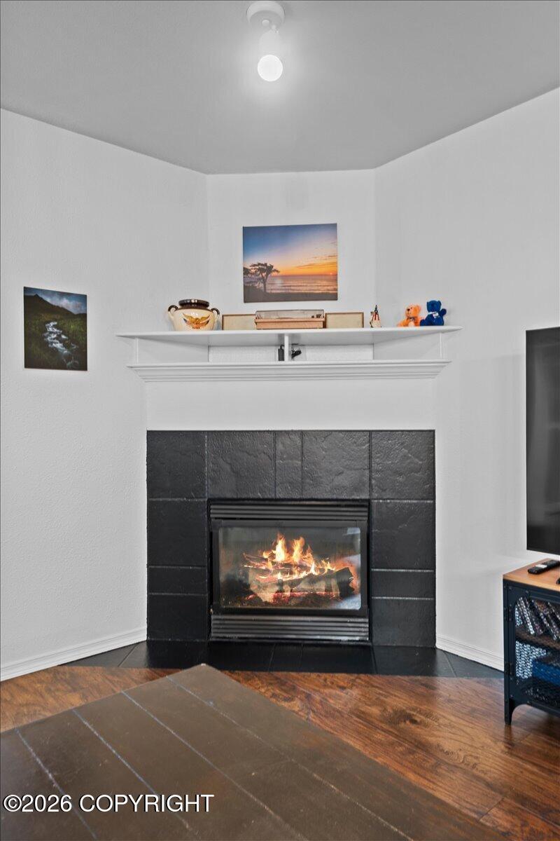 Living room fireplace with a dark slate-tile surround, white mantel, and wood flooring.