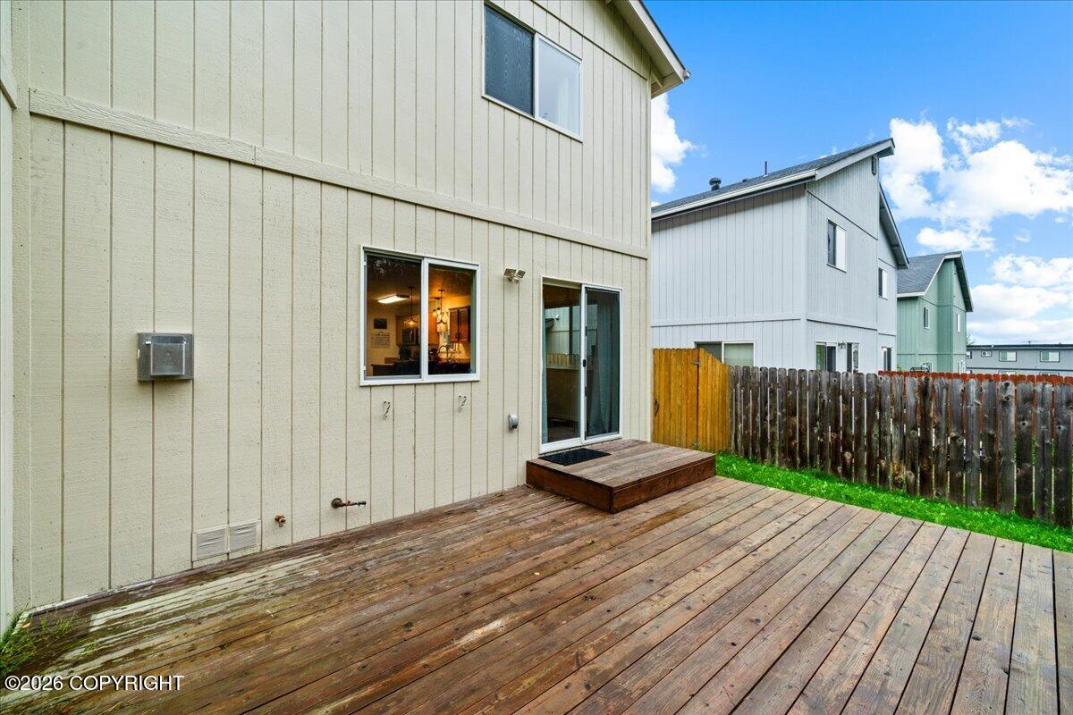 Townhouse rear deck with a raised platform, sliding glass door, and fenced yard.