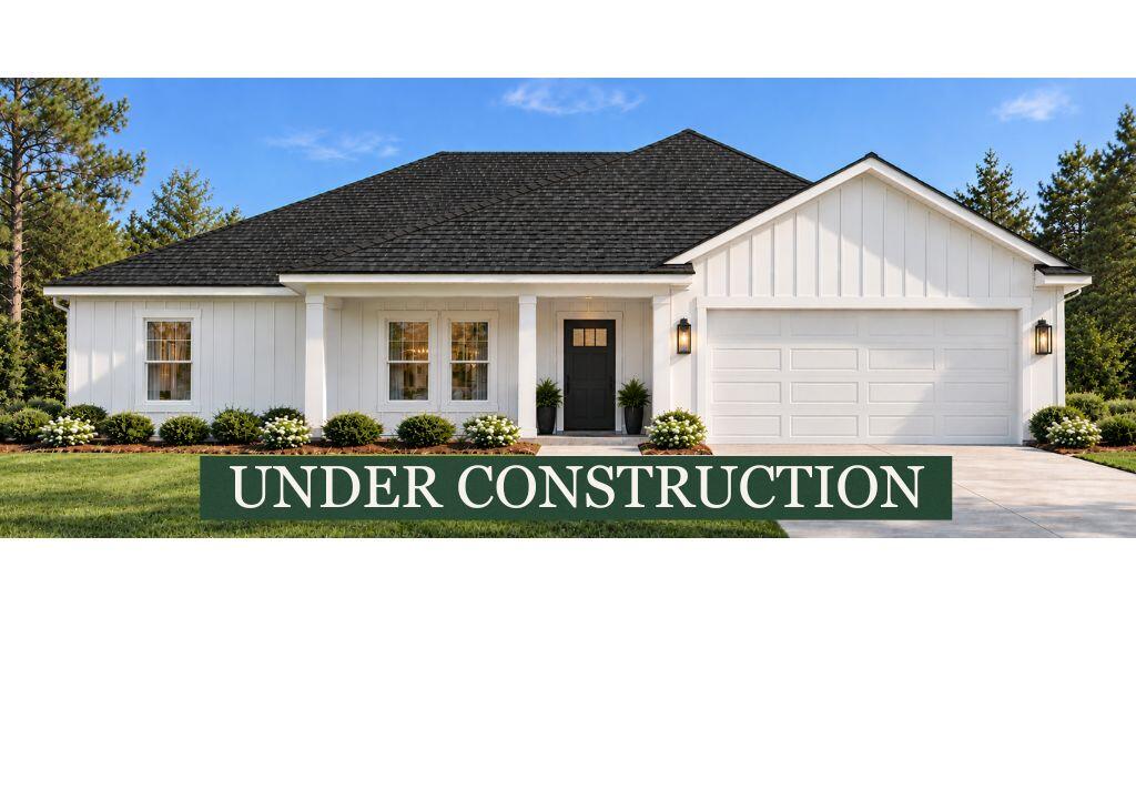 White single-story house with an “UNDER CONSTRUCTION” banner across the lawn.