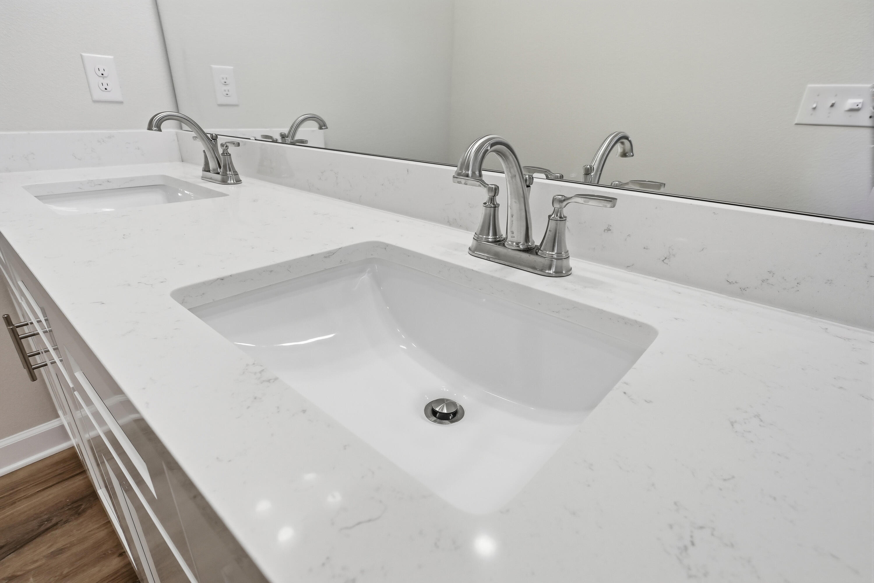 Bathroom vanity with two sinks, a marble-look countertop, and chrome faucets.