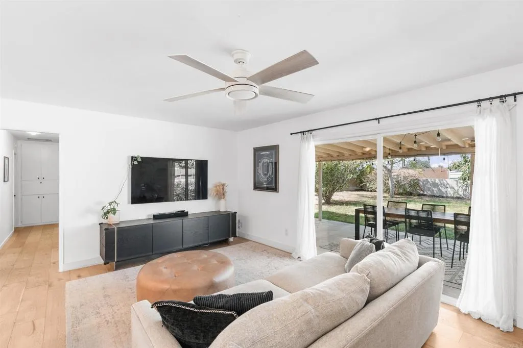 Living room with a light sectional sofa and sliding doors opening to a covered patio.