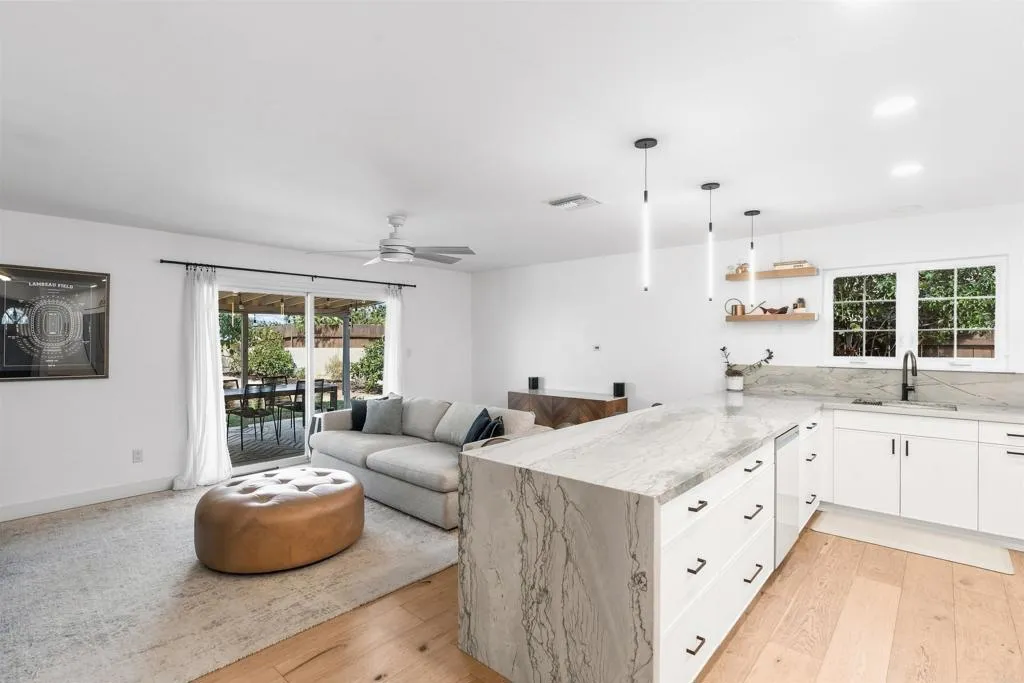 Open-plan kitchen and living room with a marble island and sliding doors to the patio.