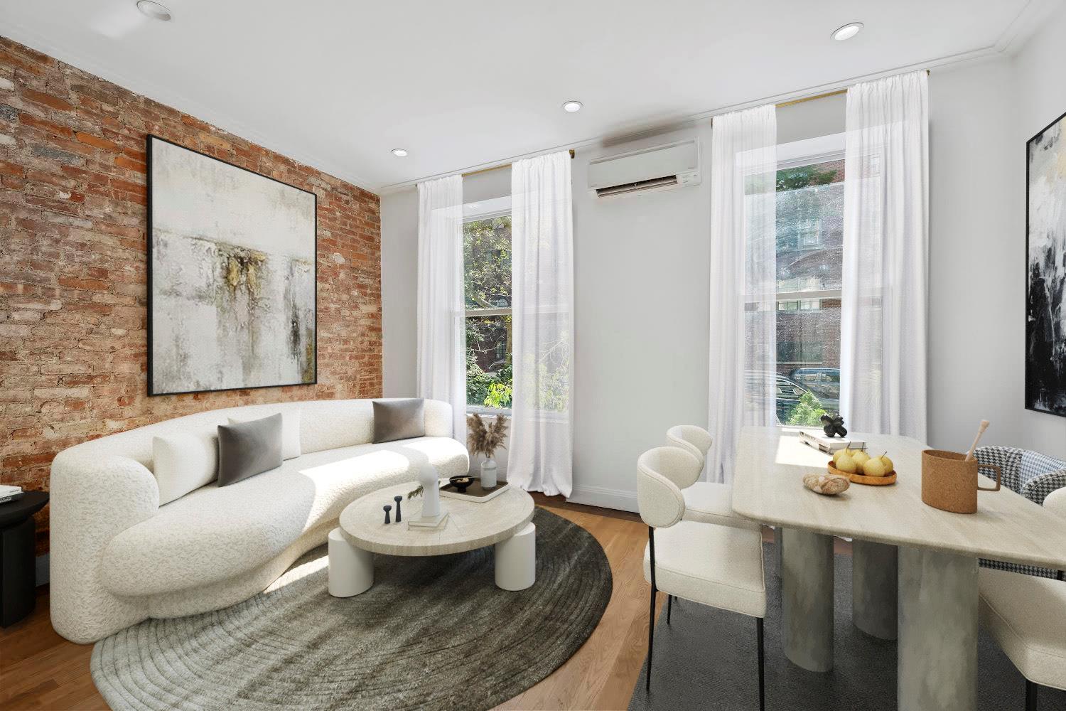 Furnished living and dining room with an exposed brick wall, curved sofa, and tall curtained windows.