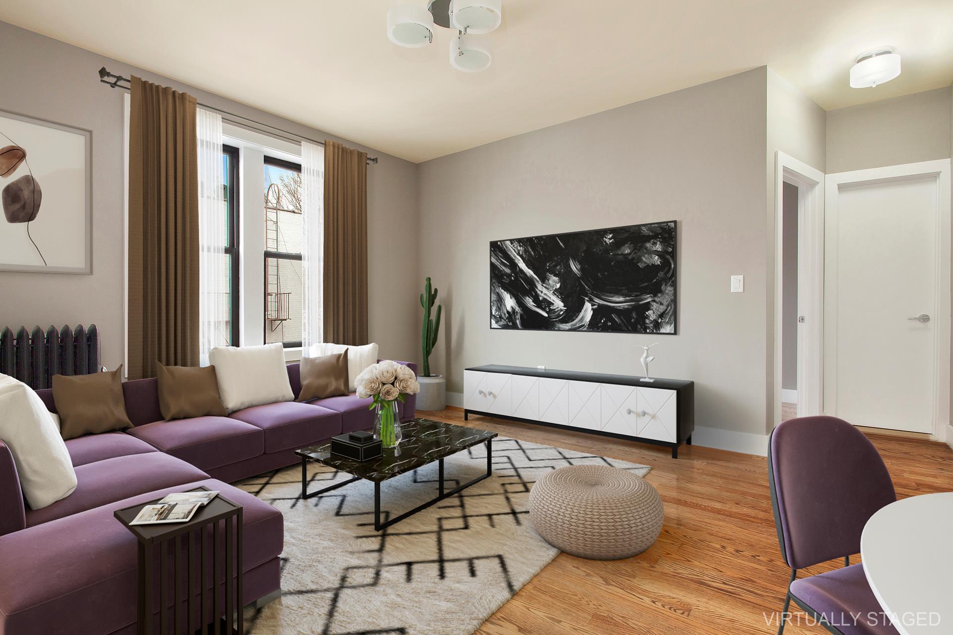 Living room with a purple sectional, marble coffee table, and tall curtained windows.