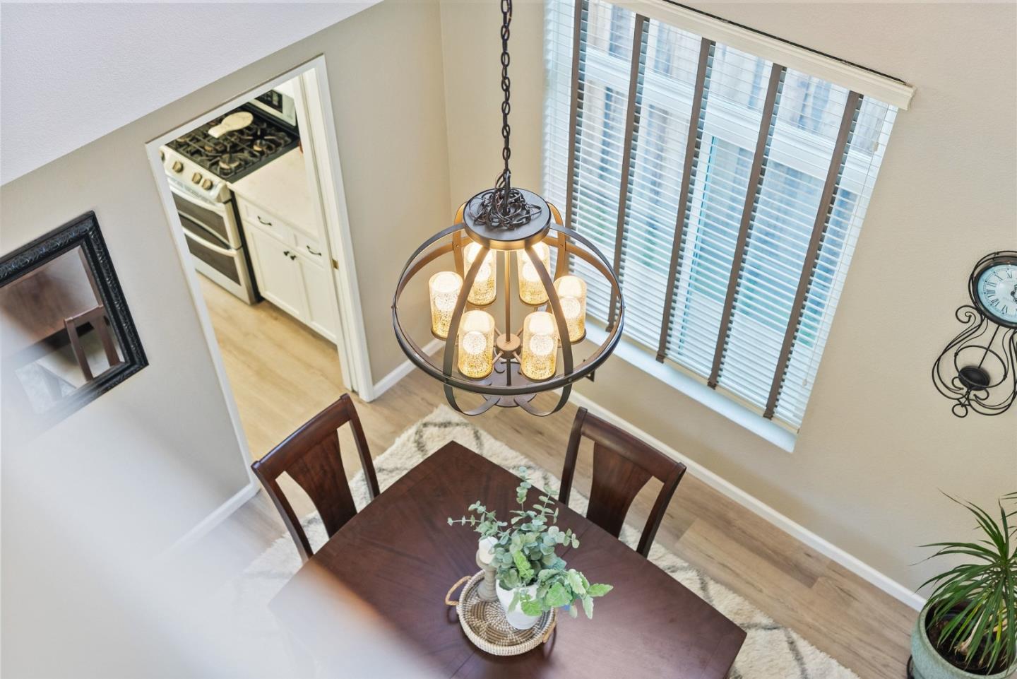 Dining room with a dark wood table beneath a large chandelier, viewed from above.