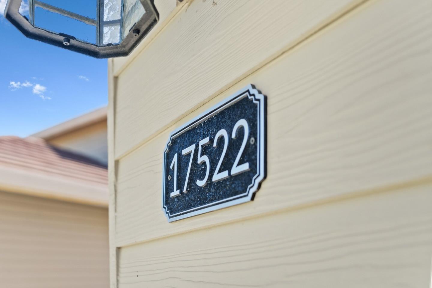 House number 17522 on cream siding beneath an exterior lantern.