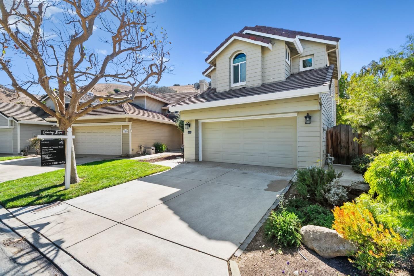 Two-story home with a double garage, broad driveway, and Coming Soon sign beside the lawn.