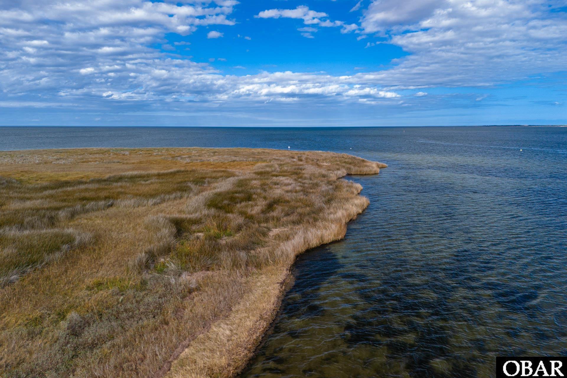 Waterfront island lot edged with tawny marsh grasses and open water.