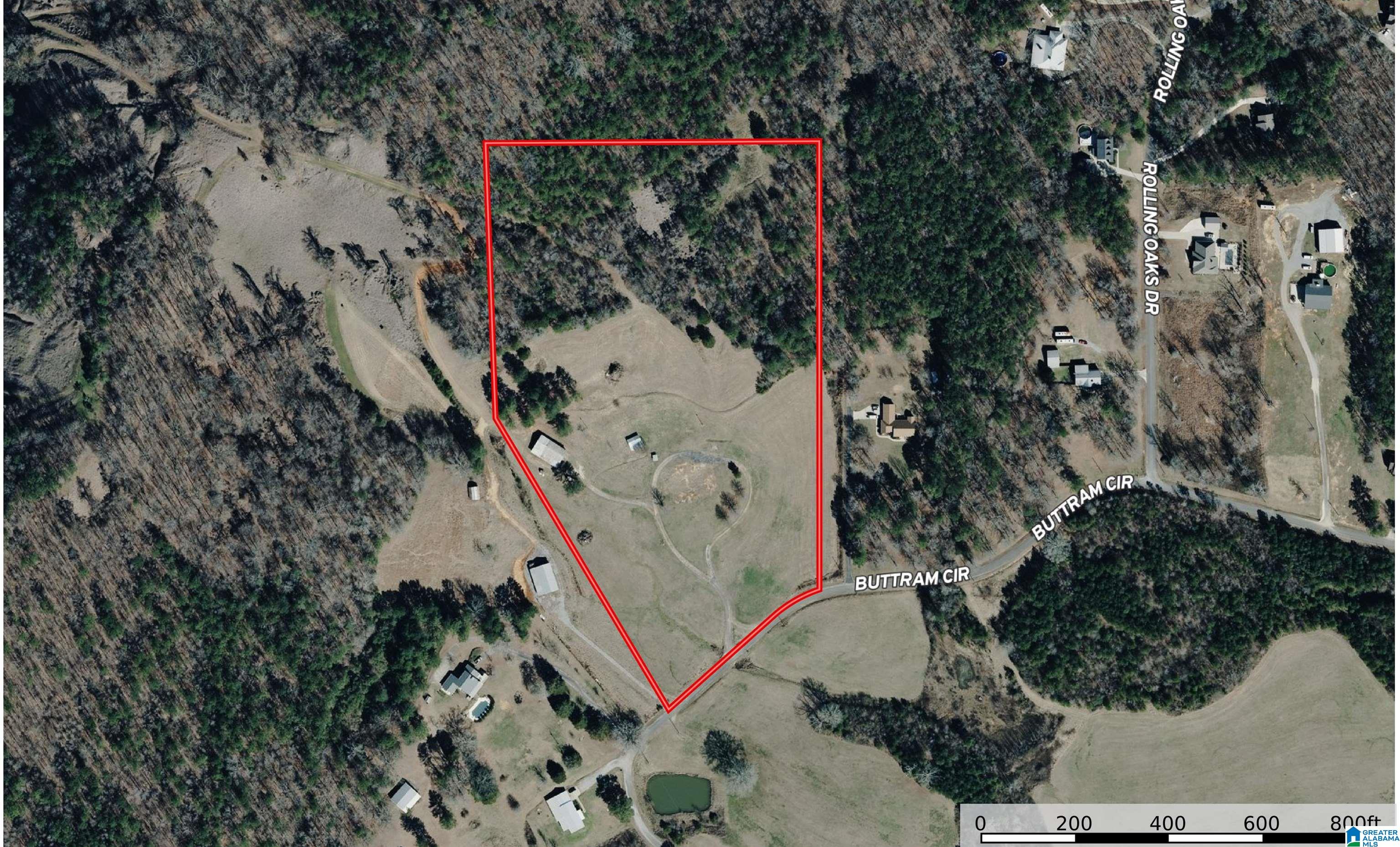 Aerial view of a wooded property with a red boundary outline and cleared land.
