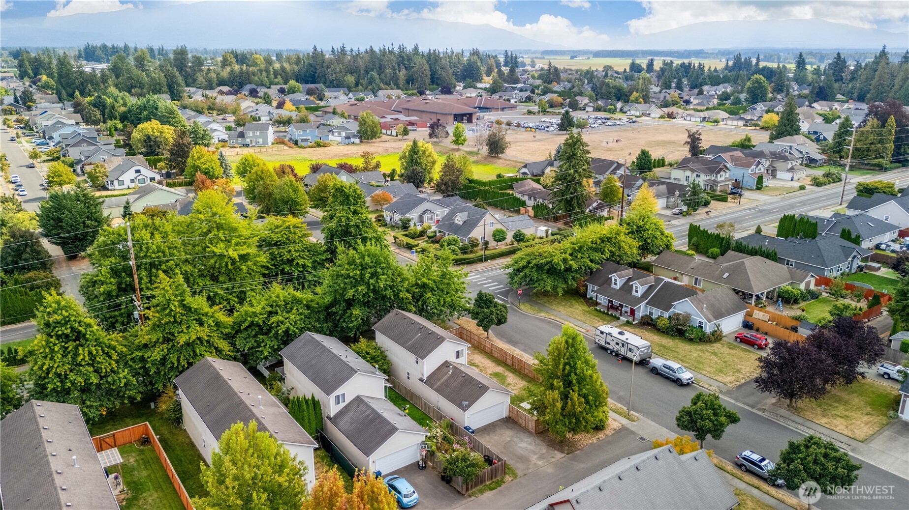 Aerial view of a residential neighborhood with distant mountains and surrounding homes.
