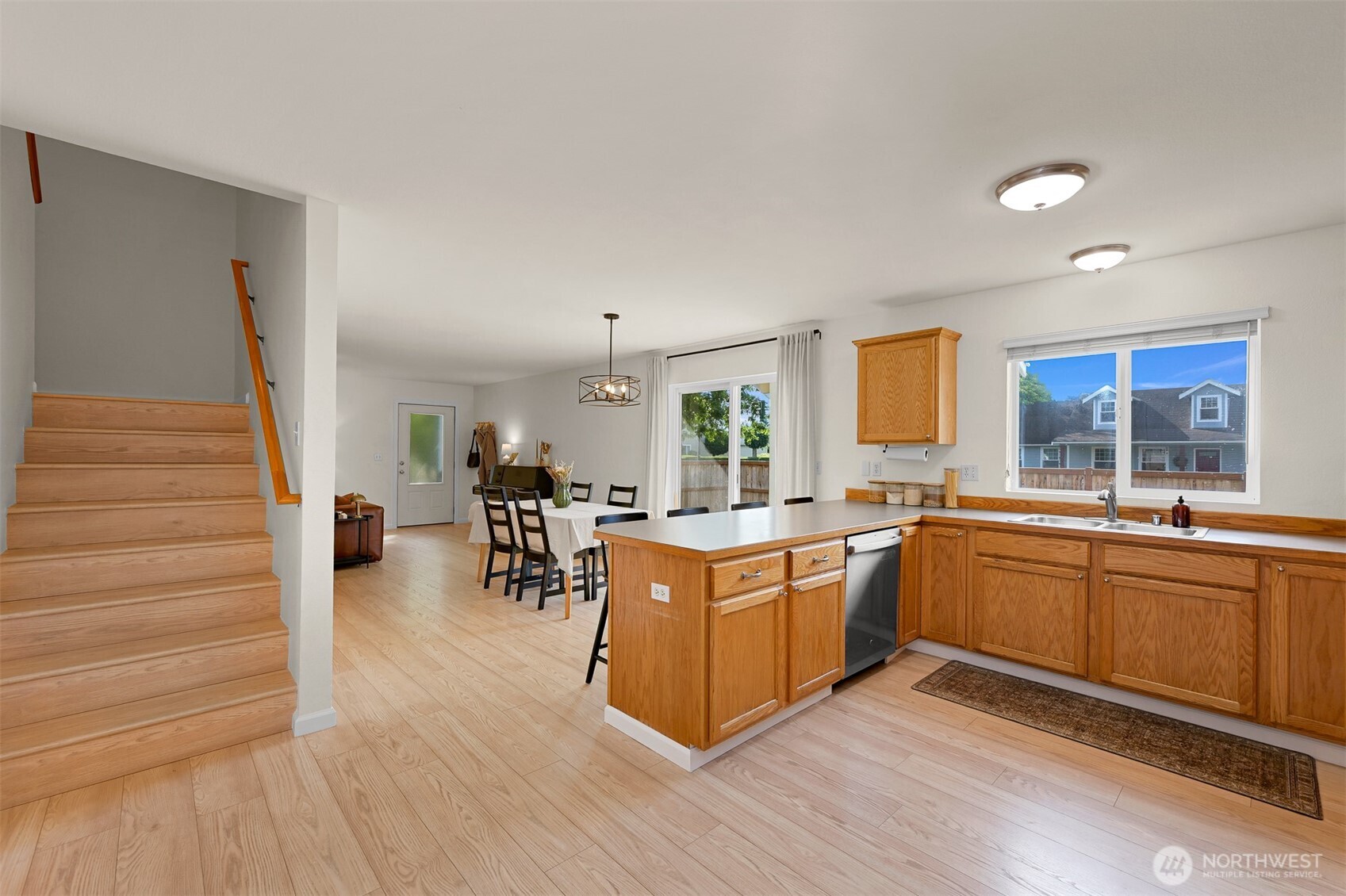 Open-plan kitchen with a wood island, dining table, and staircase.