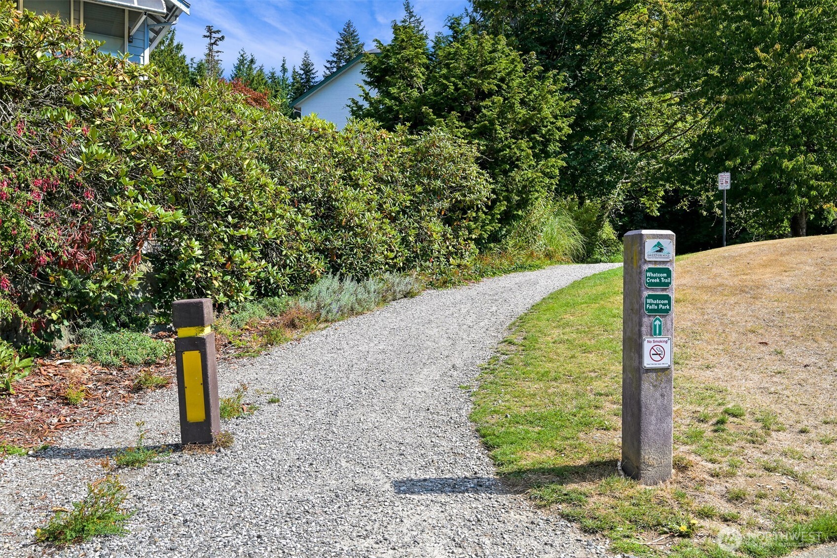 Gravel trail through greenery, marked for Whatcom Creek Trail and Whatcom Falls Park.