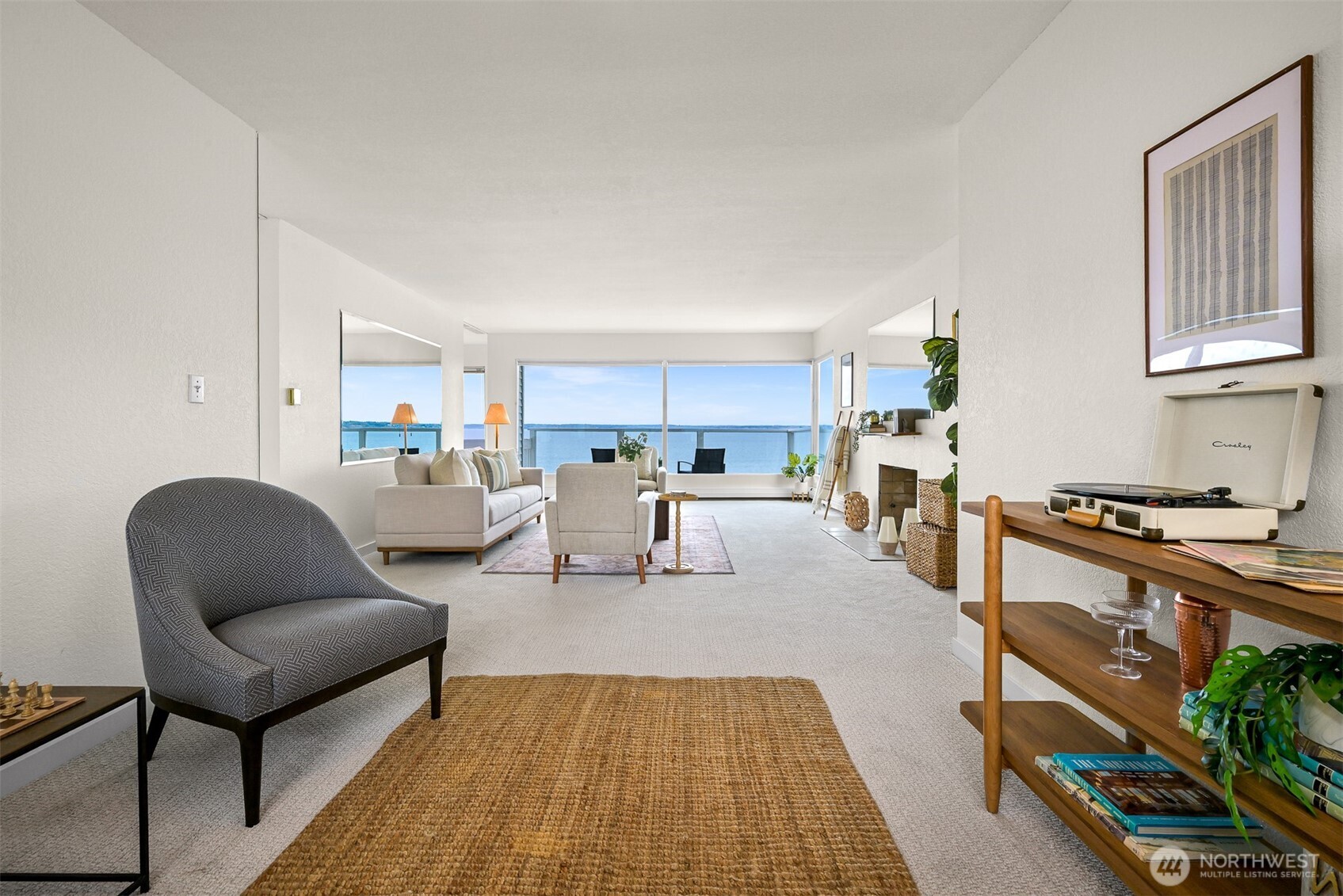 Living room with a fireplace and large windows overlooking the water.
