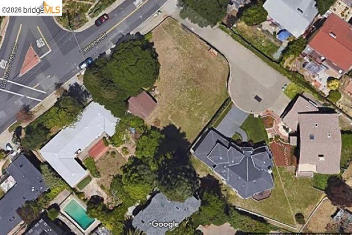 Aerial view of a grassy vacant lot on Terrace Drive, surrounded by homes and trees.