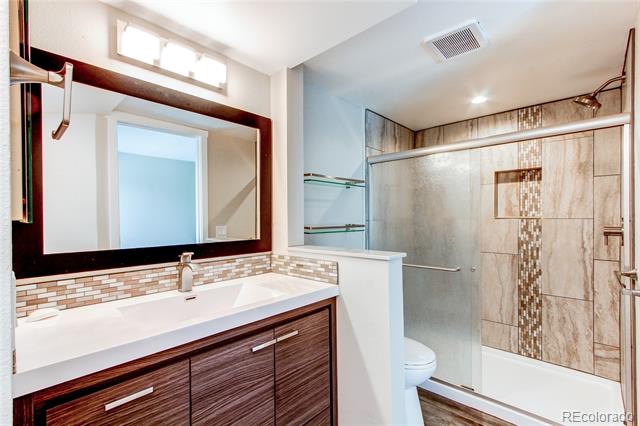 Bathroom with a dark wood vanity, large mirror, and tiled tub-shower enclosure.