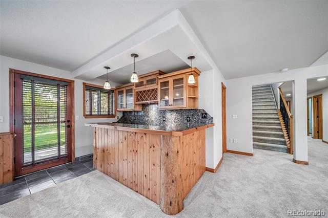 Kitchen with a wood-paneled breakfast bar, granite counters, and sliding glass doors overlooking a green yard.